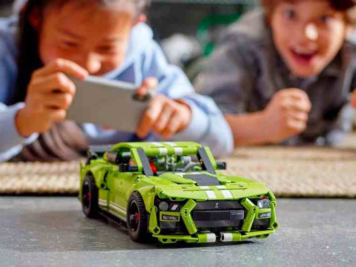 İki çocuk Lego Technic Ford Mustang Shelby GT500 ile oynuyor.