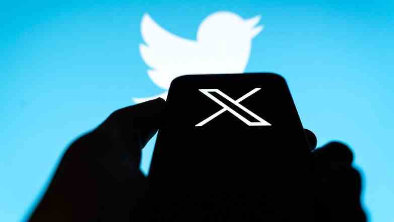 Ekranında X logosu bulunan cep telefonunun yanındaki Twitter kuşu