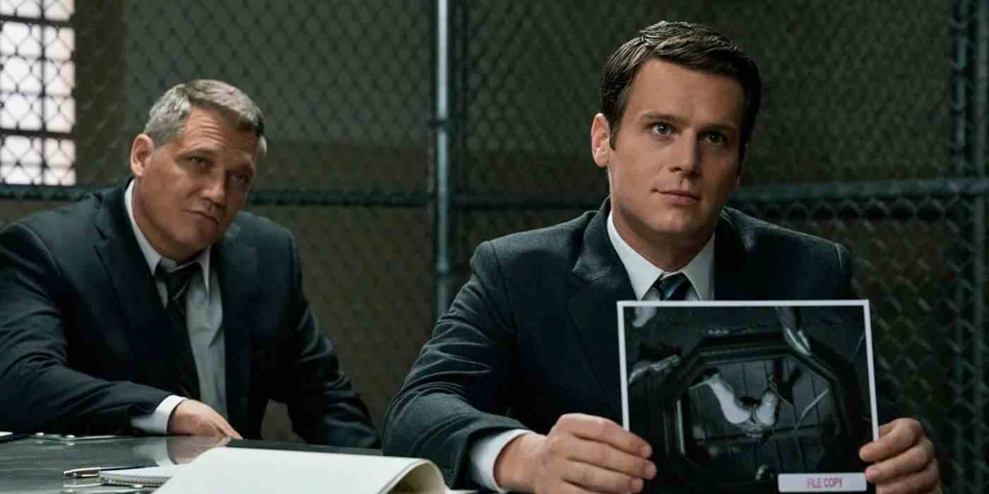 Mindhunter'da bir resmi tutan Holden Ford rolünde Jonathan Groff ve Bill Tench rolünde Holt McCallany