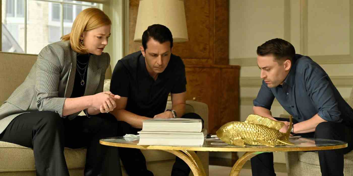 Succession 4. sezon 4. bölüm Balayı Devletleri'nde Shiv (Sarah Snook), Kendall (Jeremy Strong) ve Roman (Kieran Culkin) eğilip telefonda birlikte konuşuyorlar.