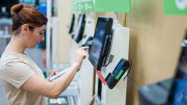 Bir kadın kendi kendine ödeme kioskunu kullanıyor