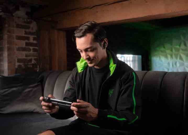 Bir adam kanepesinde Razer Kishi V2 oynuyor.