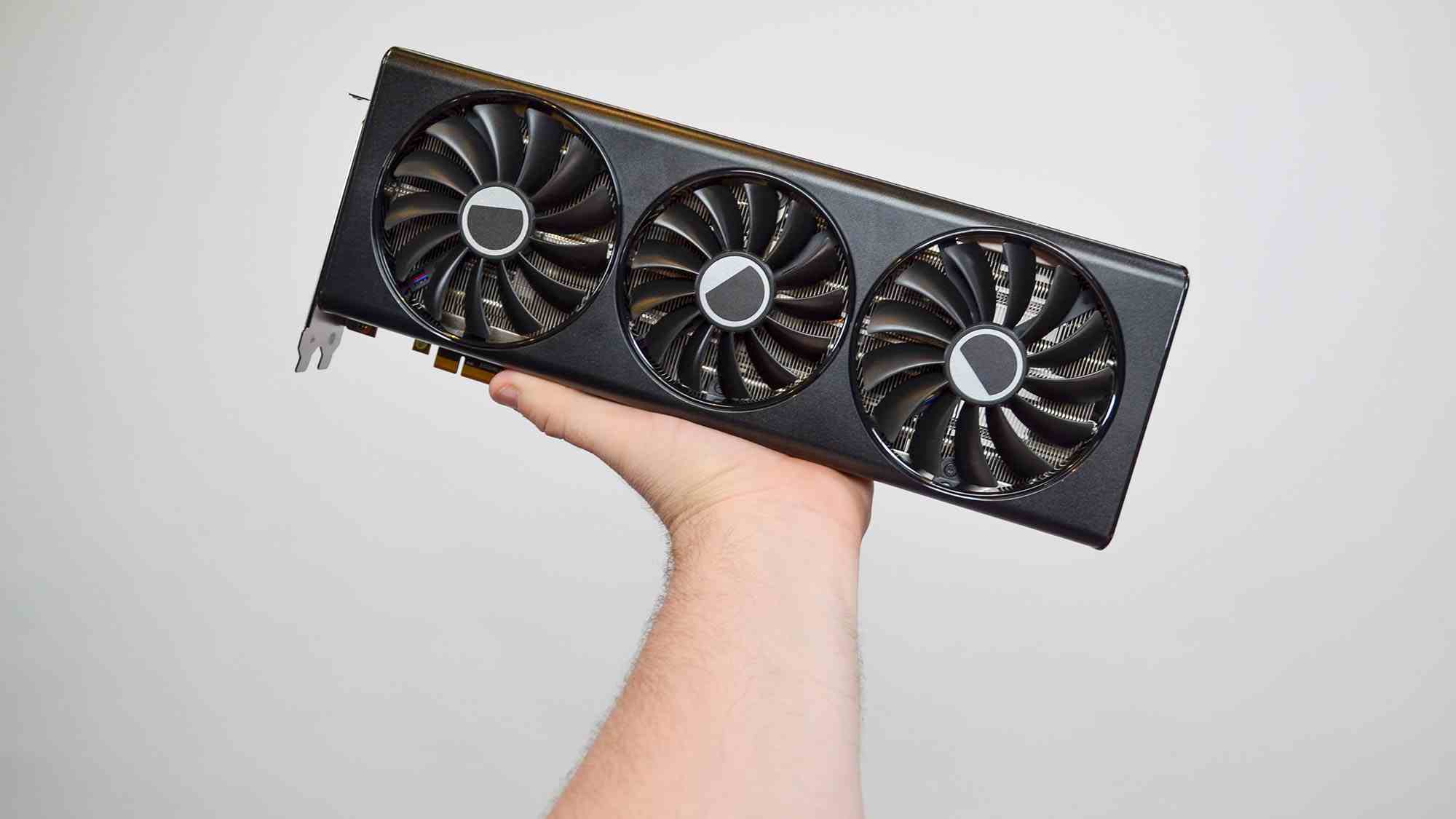 AMD Radeon RX 7700 XT'yi tutan erkeksi bir el