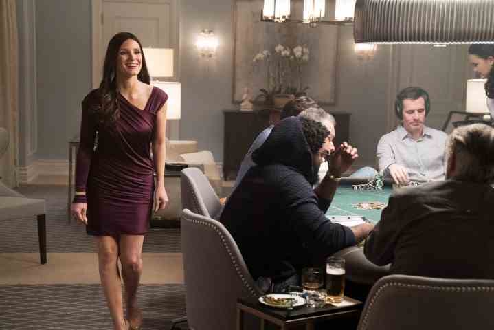 Molly's Game'de bir kadın poker masasının yanından geçiyor.