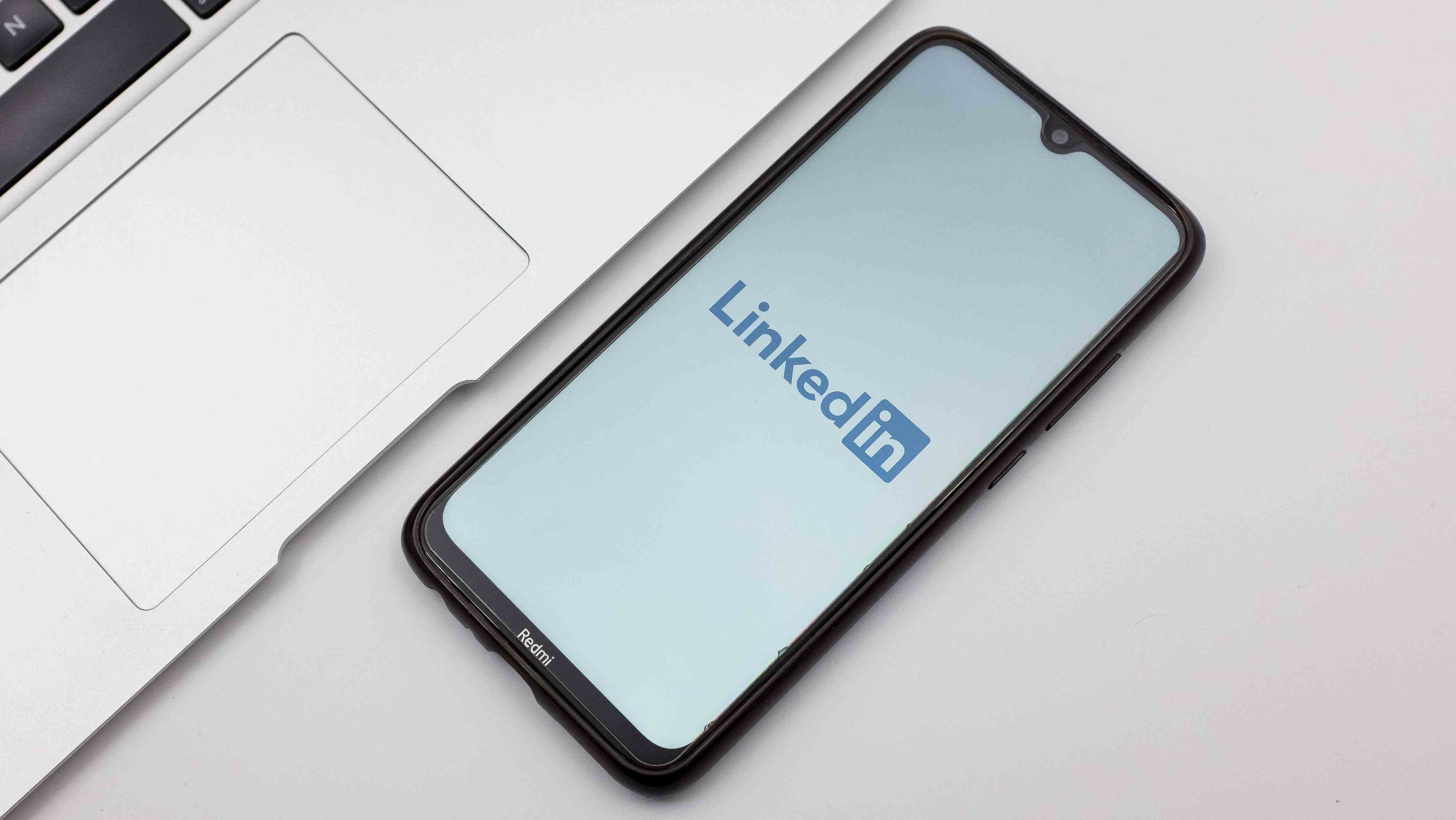 Masanın üzerindeki akıllı telefonda görüntülenen LinkedIn mobil uygulaması